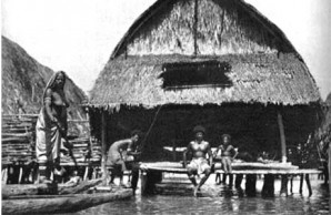 verandaHE VERANDA AT HIGH TIDE: The houses are built upon high piles, and at low tide stand some ten to twelve feet above water level. But at high tide, the lagoon deepens and the veranda becomes a convenient land platform for the canoes which are the only means of transportation in this water Venice. 