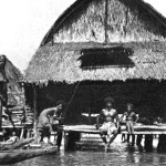 verandaHE VERANDA AT HIGH TIDE: The houses are built upon high piles, and at low tide stand some ten to twelve feet above water level. But at high tide, the lagoon deepens and the veranda becomes a convenient land platform for the canoes which are the only means of transportation in this water Venice. 